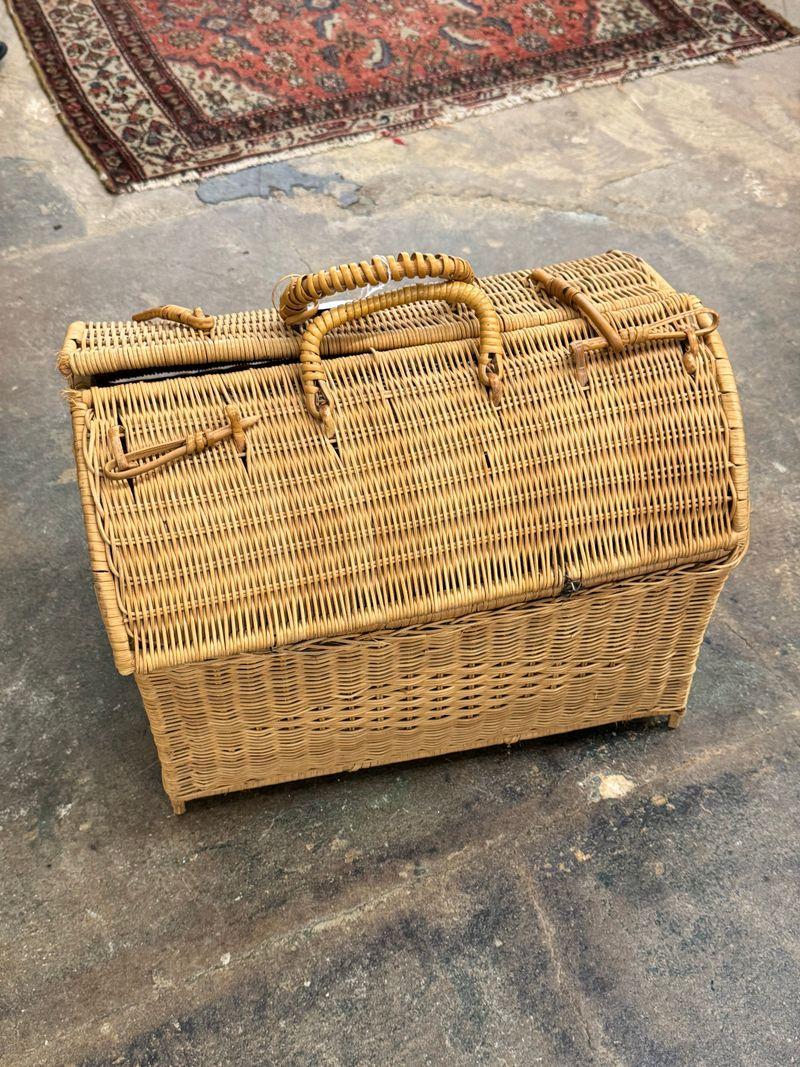 Vintage wicker picnic basket on a concrete floor at a vendor booth